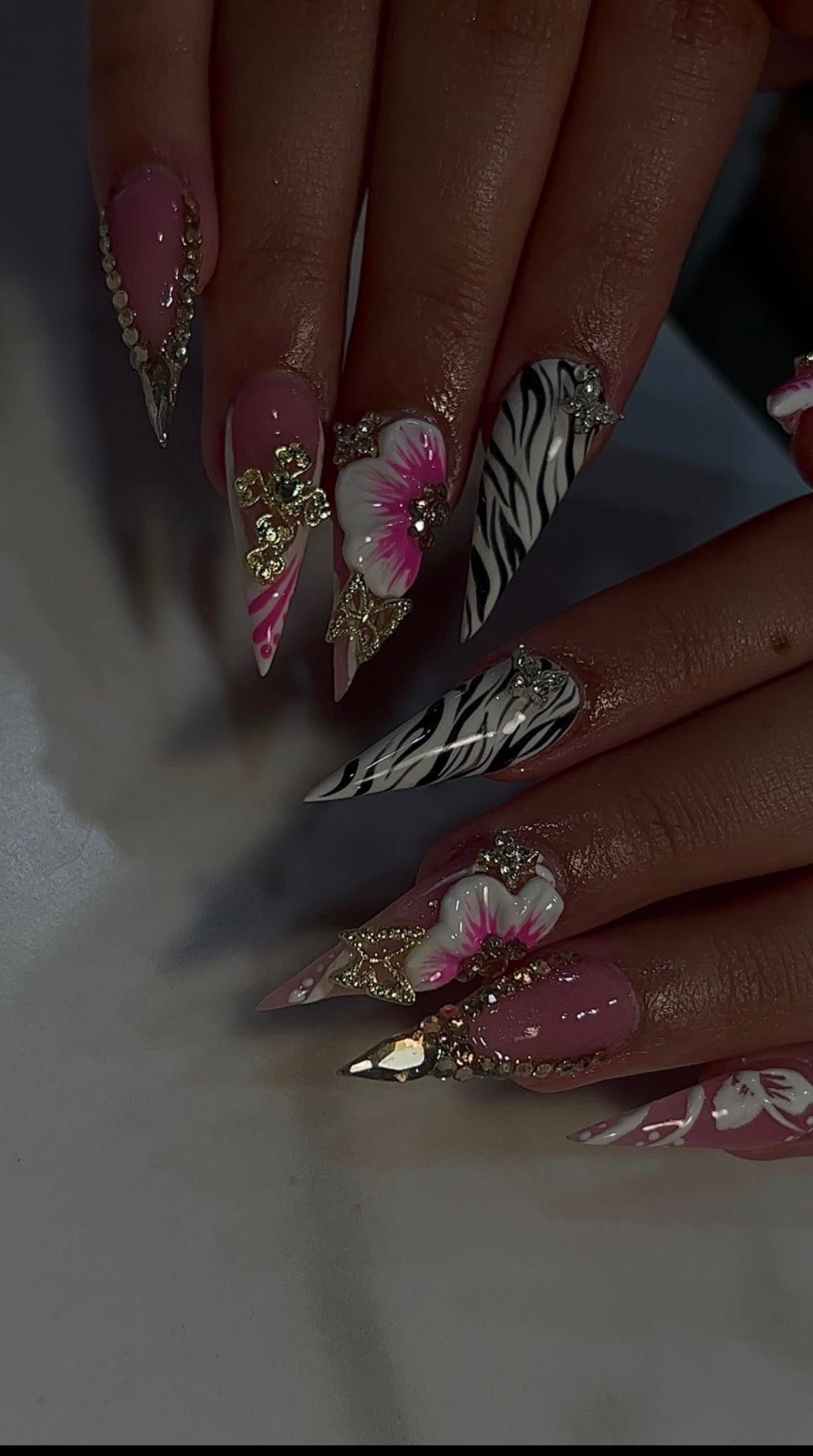 Pink stiletto nails with zebra print, 3D hibiscus & gold charms